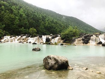 Scenic view of rocks and trees against sky