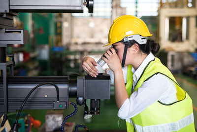 Woman wearing hardhat working in factory