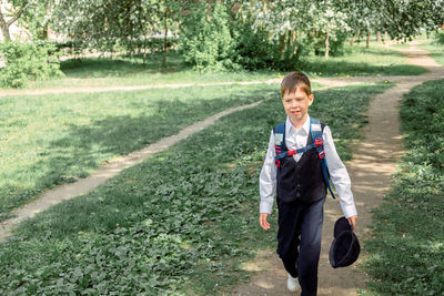 Happy boy with a backpack and a cap goes to school. the beginning of the new school year 