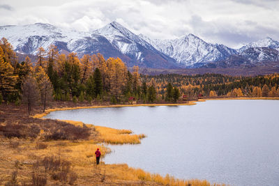 Scenic view of lake by snowcapped mountains against sky