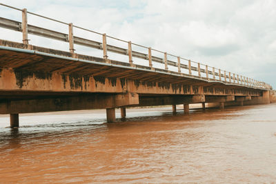 Bridge over calm sea against sky