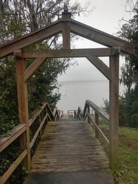 Wooden bridge over water against sky