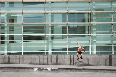 Full length of woman jumping in city