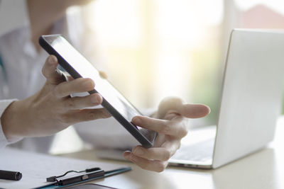 Midsection of man using mobile phone