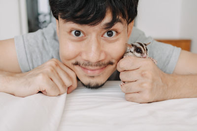 Portrait of young man lying on bed at home