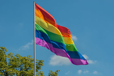 Low angle view of flags against blue sky