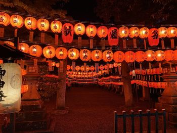 Illuminated lanterns hanging in temple at night