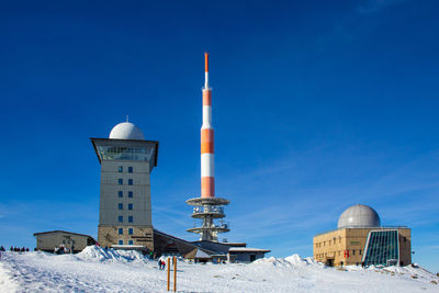 View of snow covered tower against blue sky