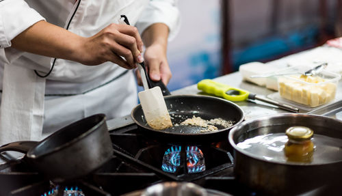 Midsection of man preparing food in kitchen