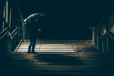 Low angle view of man standing on steps at night