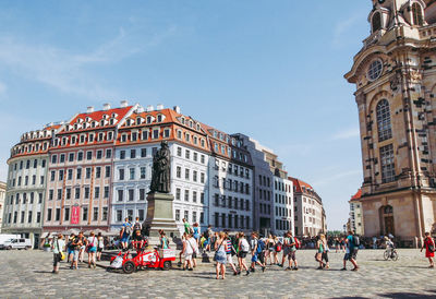 People on street against buildings in town