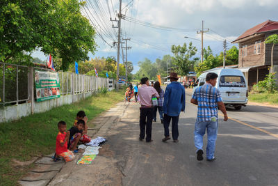 People on road amidst trees