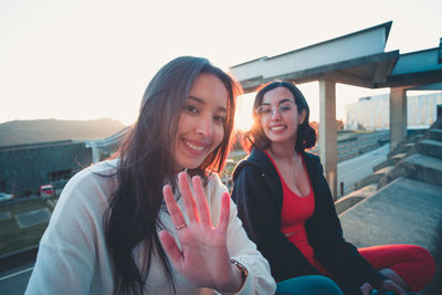 Portrait of smiling young woman against sky