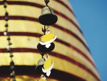 Low angle view of bell hanging against clear sky