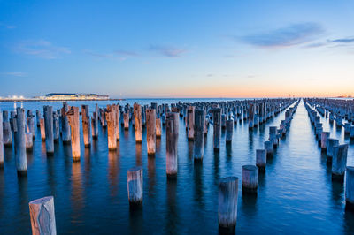 Old wooden pylons of historic princes pier in port melbourne at dusk.