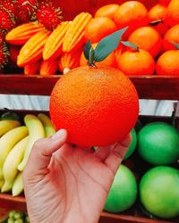 Close-up of hand holding plastic orange