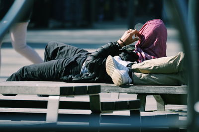 Side view of man sitting on bench