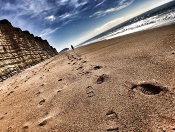 Scenic view of beach against cloudy sky