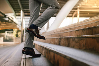 Low section of man walking on staircase