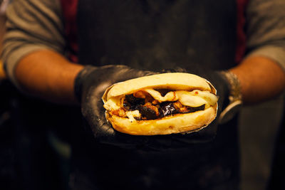 Midsection of man holding a delicious sandwich