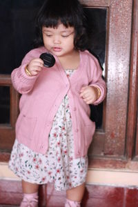 Full length of girl holding pink while standing