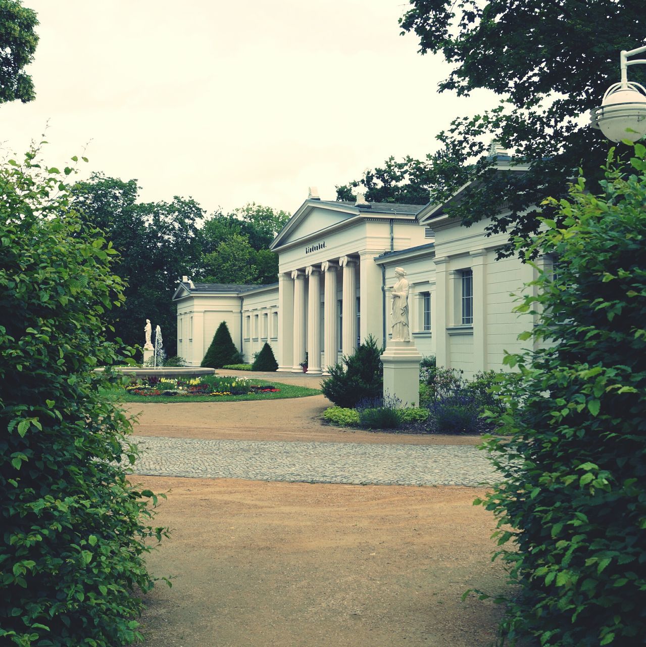 architecture, building exterior, built structure, tree, plant, facade, sky, growth, lawn, day, outdoors, arch, clear sky, formal garden, incidental people, history, no people, green color, travel destinations, house