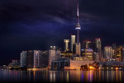 Illuminated cityscape against sky at night