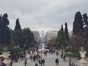 People walking on street in city against sky