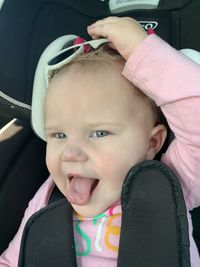 Portrait of cute baby girl in car