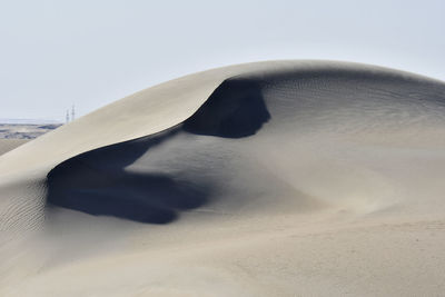 Scenic view of sand dunes against sky