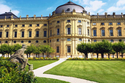 Frontal view of the würzburg castle from the garden side. above that blue sky with white clouds. 