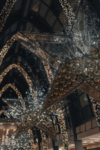 Low angle view of illuminated lights hanging on ceiling in building