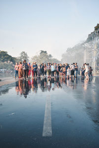 Group of people on road against clear sky