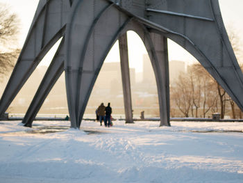 People walking under bridge during winter