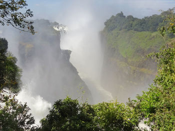 Scenic view of waterfall against sky