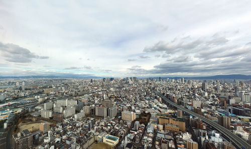 High angle view of crowd and buildings in city against sky