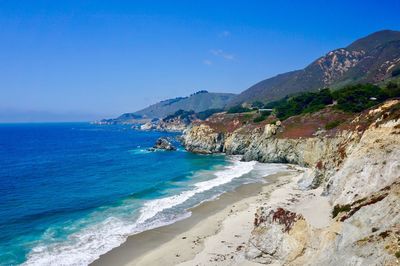 Scenic view of beach against clear blue sky