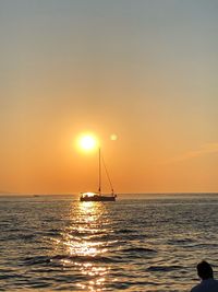 Silhouette sailboat in sea against sky during sunset