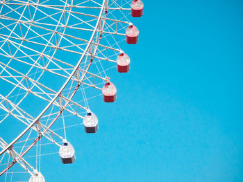 Low angle view of ferris wheel against clear blue sky