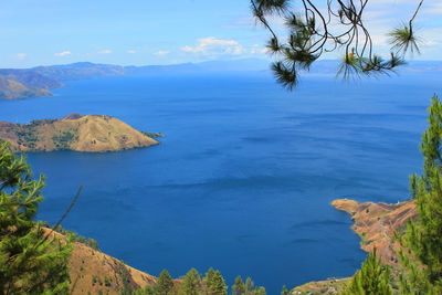 Scenic view of sea and mountains against sky