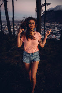 Portrait of young woman standing on field