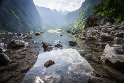 Pristine alpine lake nested amongst mountains and high stone walls, obersee, germany