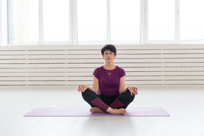 Full length of man sitting on wooden floor