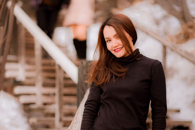 Portrait of smiling young woman standing outdoors