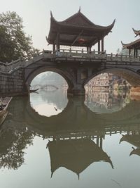 Arch bridge over lake against buildings