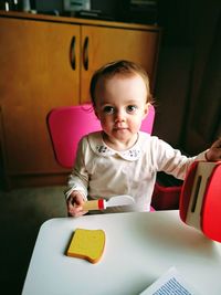 Portrait of cute baby girl playing with toys at home