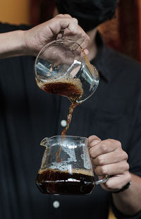 Close-up of hand pouring water from glass