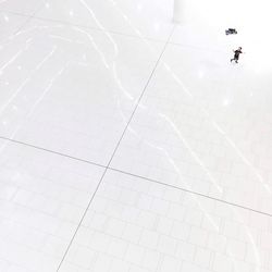 High angle view of person shadow on tiled floor