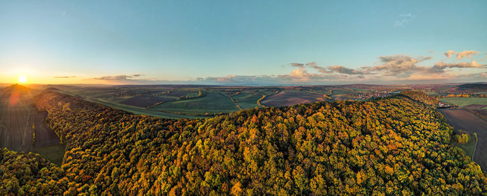 Scenic view of agricultural landscape against sky during sunset