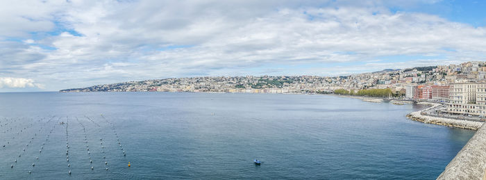 Panoramic view of city by sea against sky